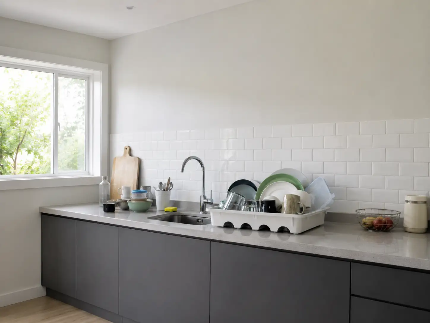 Mesón de cocina desordenado con escurridor de plástico y platos apilados